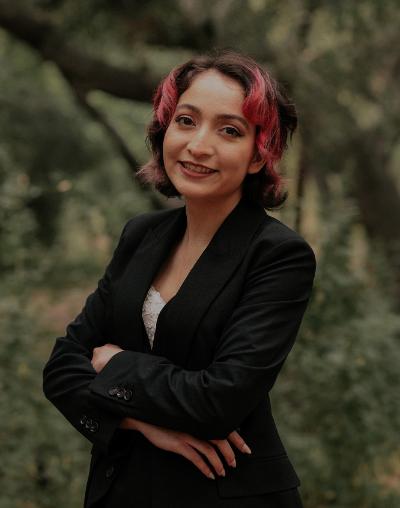 student in black jacket in front of a tree